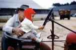 Grandpa teaches grandson to drive tractor, January 1960, 1960s, PBTV05P02_18