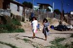women walking, dirt street, homes, houses, Colonia Flores Magone, PFSV02P02_19