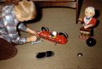Boy with Fire Bird Toy Race Car fixing tires, 1950s, PHCV05P08_18