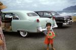 Cadillac, beach, Girl selling hats, cars, Kahana Bay, June 1956, 1950s, VCRV21P13_18